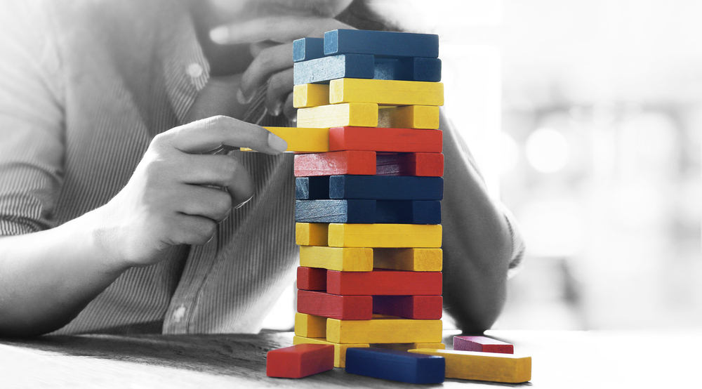 Abstract photo of a person playing Jenga to demonstrate the importance of strategic planning