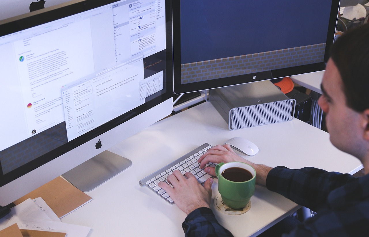 An image of a modern office desk with a laptop, calculator, and various financial documents